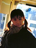 gMinori Aoi on a train wearing an out of season winter jacket